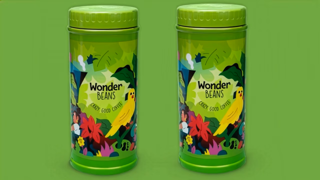 Twee groene koffieblikken van Wonder Beans met een illustratie van een jungle en een gele vogel